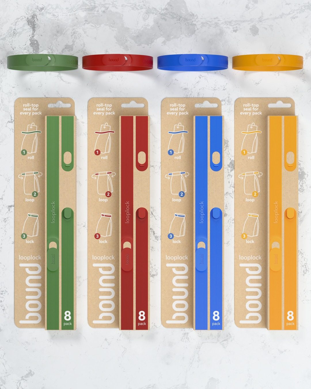 Four Looplock packs on a marble benchtop, Kiwi, Strawberry, Blueberry and Mango, each with a locked loop
